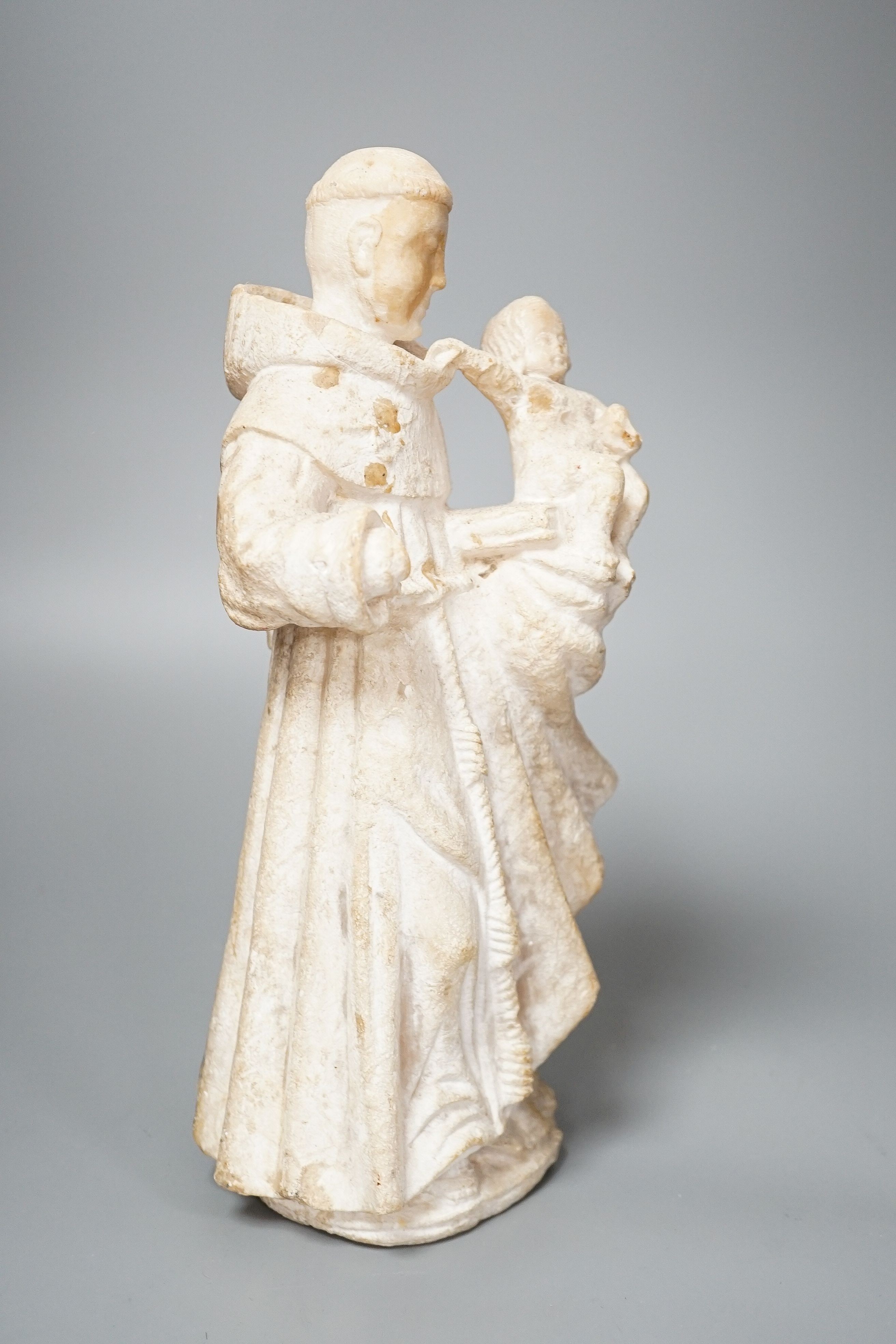 A 19th century carved alabaster group, friar with child 28cm